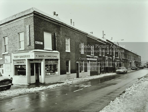 Wells Way, Nos 106-68, looking north by Parkhouse Street. Toby Bakeries selling Hovis, Brooke Bond tea and Lyons’s tea, c1968.  X..png