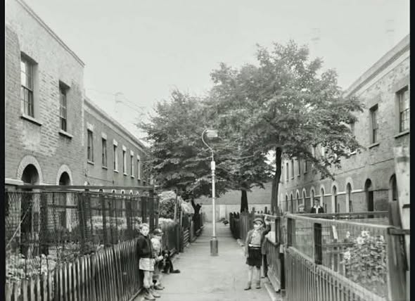 Vaughan Place, left 9-15, right 1-6, far end behind a high brick wall are the iron frames of two gas storage tanks in the South Metropolitan Gas Works. X..png